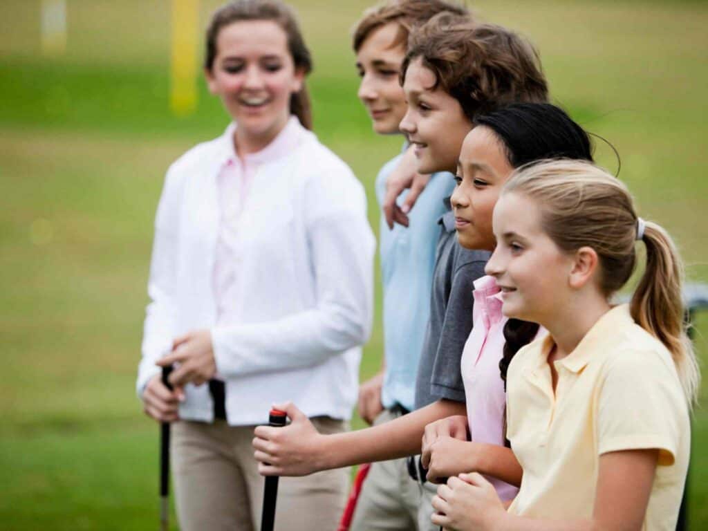 Children standing in a queue at a golf tournament at school's spring fundraiser