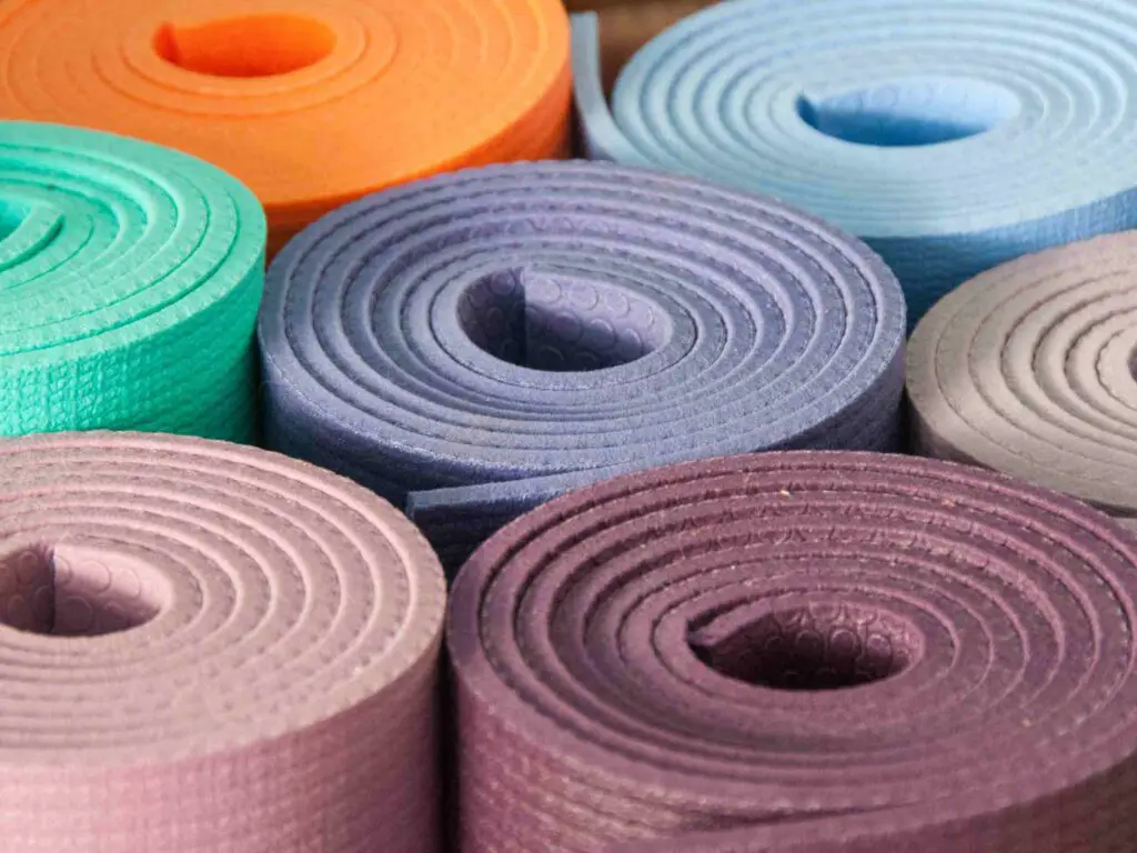 Rolled yoga mats in different colors seen from the top - sold as a way to raise funds for a yoga club