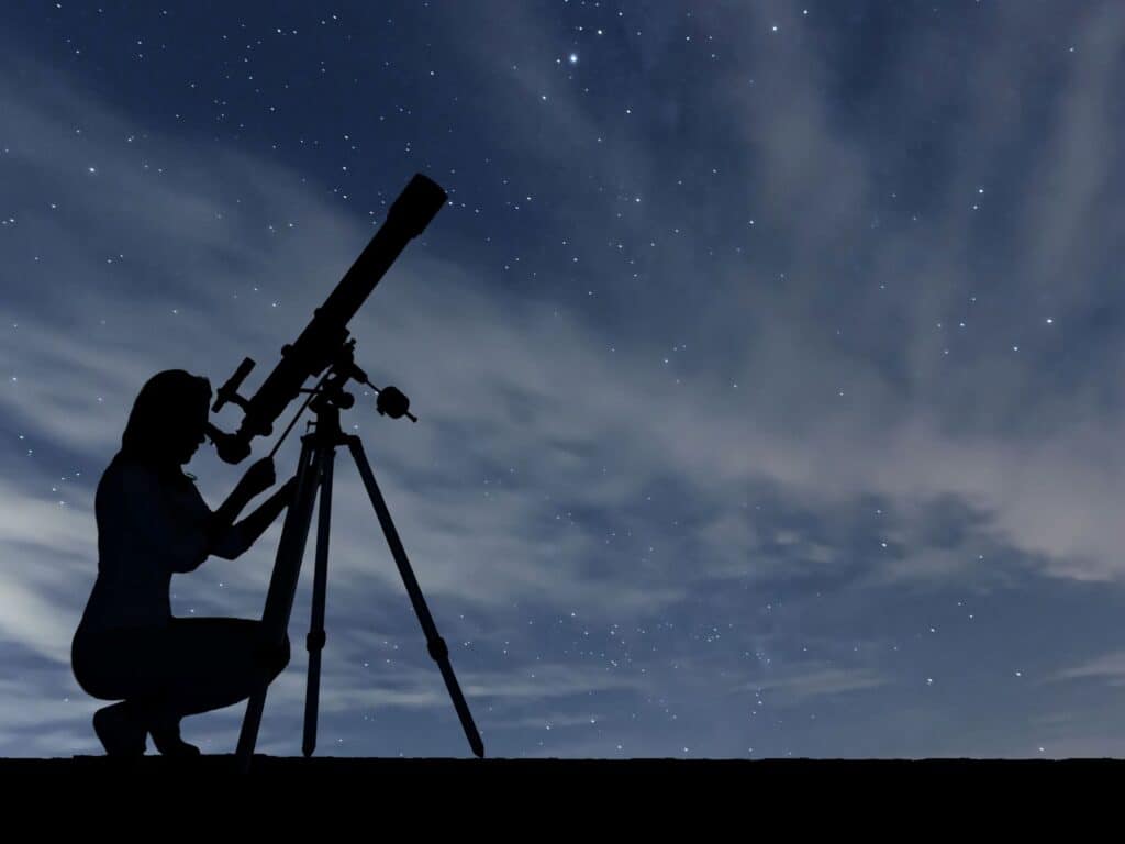 women looking at night sky through telescope as one of the night time summer fundraising ideas
