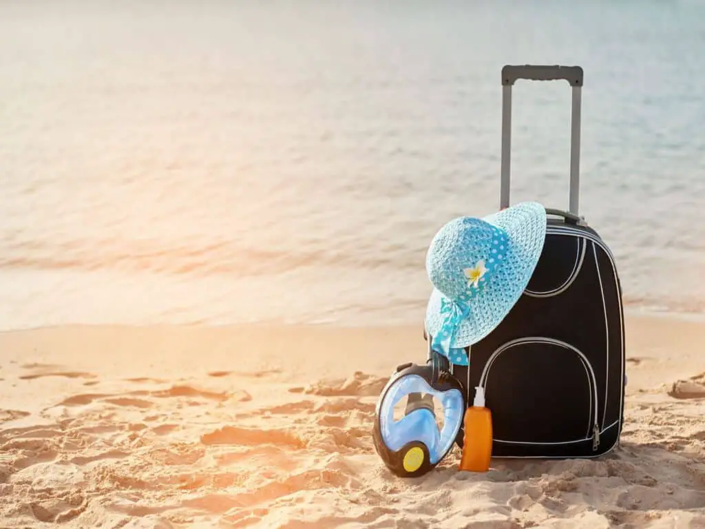 travel bag , hat at the beach on sand